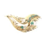 A vintage emerald abstract scrolling leaf brooch.