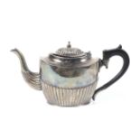 A silver oval part-fluted teapot.