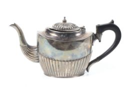 A silver oval part-fluted teapot.