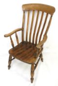 A vintage elm Windsor armchair. On turned supports united by turned stretchers.