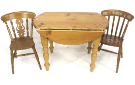 A pine drop leaf kitchen dining table and two chairs.