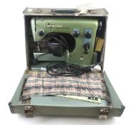 A mid-century Husqvarna Viking electric sewing machine. In a green transportation case, L42.