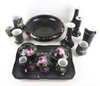 A collection of vintage black matte floral ceramics.
