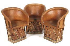 A set of three leather and wood tub chairs.