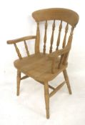 A contemporary pine carver chair. With spindle back and turned tapering supports.