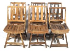 A set of six rustic wooden chairs.