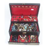 An assortment of costume jewellery in a black jewellery box.