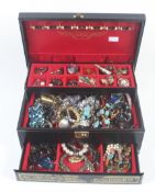 An assortment of costume jewellery in a black jewellery box.