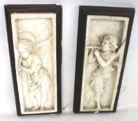 A pair of framed plaster plaques.