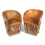A pair of wood and tan leather tub chairs.