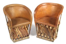 A pair of wood and tan leather tub chairs.