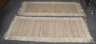 A pair of coarse woven runner rugs.