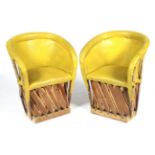 A pair of wood and yellow leather tub chairs.