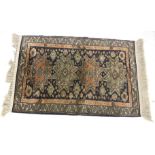 A Persian style silk blend rug. With geometric boarder and designs.