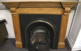 A cast metal fire place and carved pine surround.