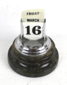 A serpentine desk calendar. Of circular form, containing date and day cards, H9.