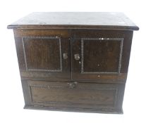 An vintage oak table top cupboard. With lid, two doors and a drop down door below.