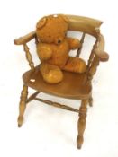 A pine smoker's bow open arm chair and a vintage teddy bear.