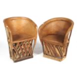 A pair of tan leather and wood tub chairs.