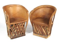 A pair of tan leather and wood tub chairs.