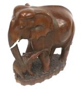 A large carved hardwood elephant and baby figure.