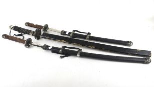 Three replica samurai swords. Max. 101cm long.