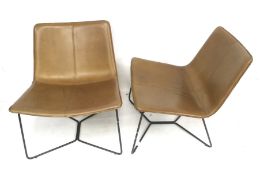 A pair of contemporary West Elm slope leather lounge chairs.