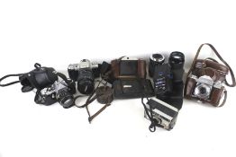 An assortment of cameras and accessories. Including a Pentax ME, a Tokina SD lens, etc.