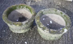 A pair of circular garden stone planters.