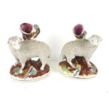 A pair of Staffordshire sheep spill vases.