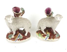 A pair of Staffordshire sheep spill vases.