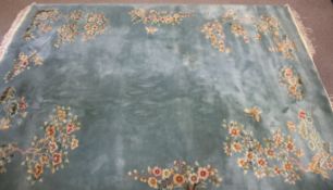 A turquoise Chinese wool rug with floral decoration.