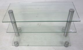 A contemporary glass three tier TV stand.