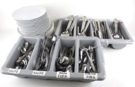 A large assortment of silver plated flatware and dinner plates.