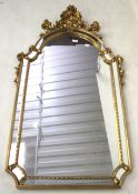 A contemporary wall mirror. The gilt wood frame with an arch top.
