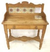 A vintage pine washstand with tiled back. With false drawer with turned supports.