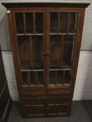 An early 20th century wooden glazed display storage cabinet.