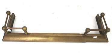 A vintage adjustable brass fire fender.