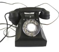 A vintage black bakelite telephone.