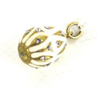 A gold-plated, paste and cream-enamel egg-shaped pendant inspired by Faberge in Russian style.