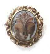 An early Victorian gilt metal and woven hair oval mourning brooch.
