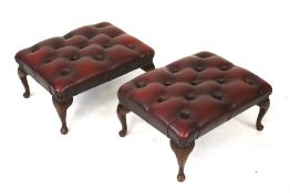 A pair of red leather 'Chesterfield' style footstools.