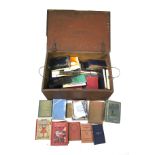 A collection of assorted vintage books in a wooden trunk.