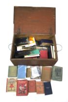 A collection of assorted vintage books in a wooden trunk.