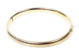 A vintage gold hollow hinged bangle.