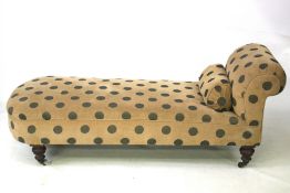 A Victorian chaise longue with 'spotty' fabric upholstery and bolster.