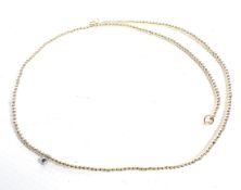 A Continental yellow metal bead necklace with a central small round brilliant diamond single stone