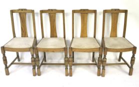 A set of four dining chairs. With oak frames and drop in seats.