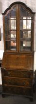 A two-piece Queen Anne style bureau display cabinet.