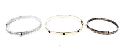 Three lady's silver bangles including one marked 'Tiffany'